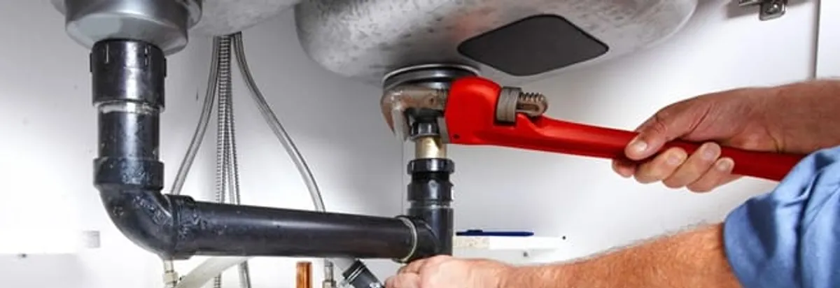 Garbage disposal repair technician tightening the sink drain and disposal connection in Rochester, NY