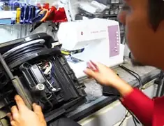 Vacuum repair technician servicing internal components on a workbench in Rochester, NY