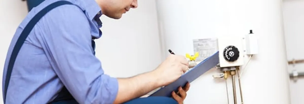 Water heater repair technician inspecting the unit and recording service notes in Rochester, NY